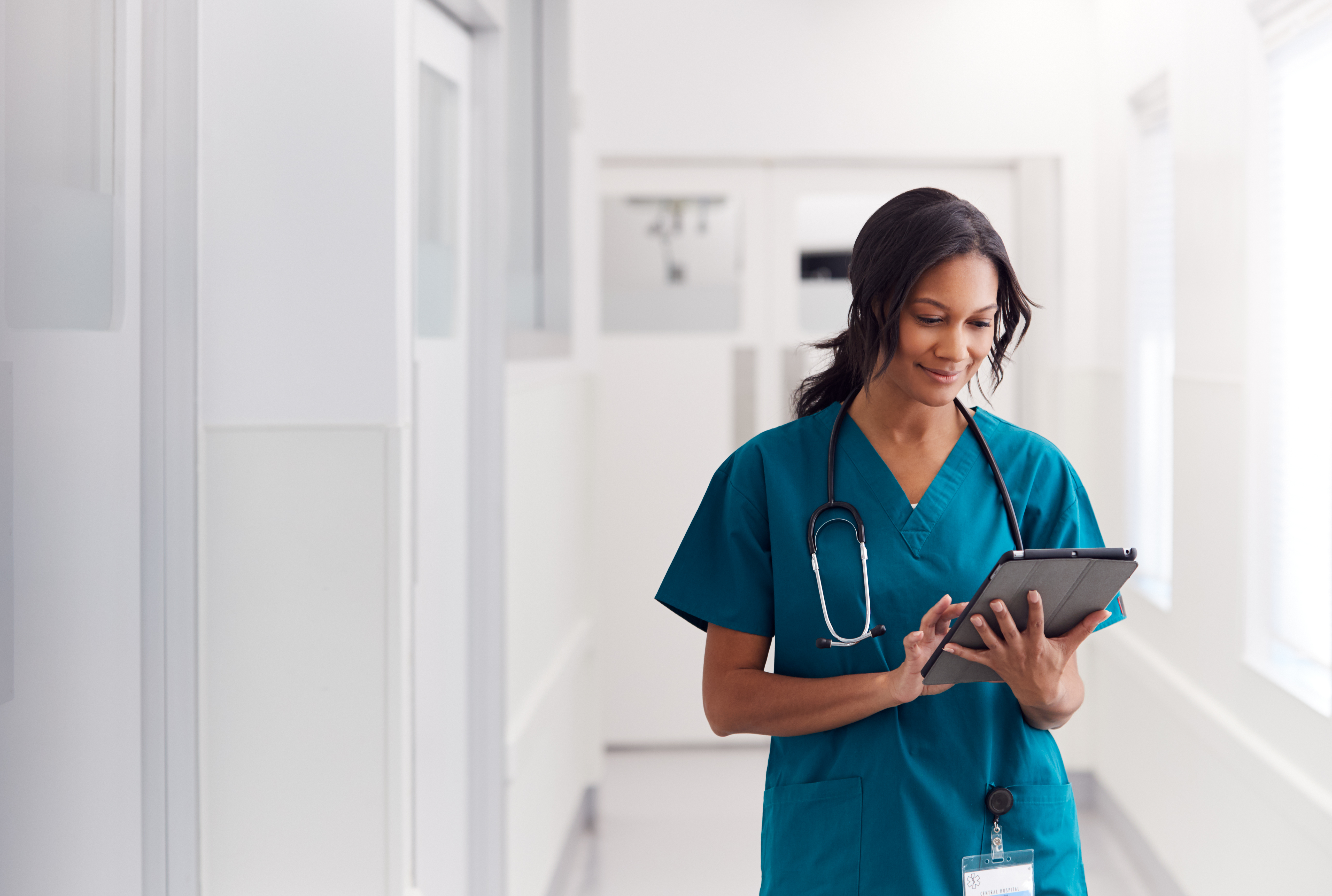 female nurse standing looking at tablet