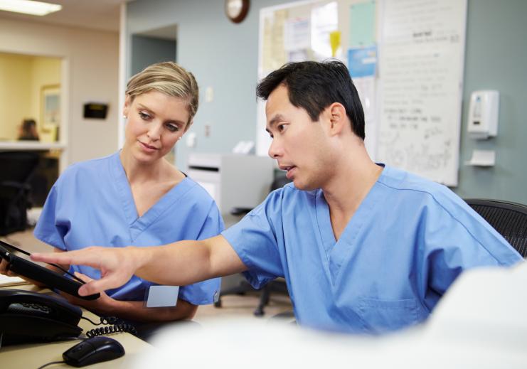 Two nurse colleagues looking at computer